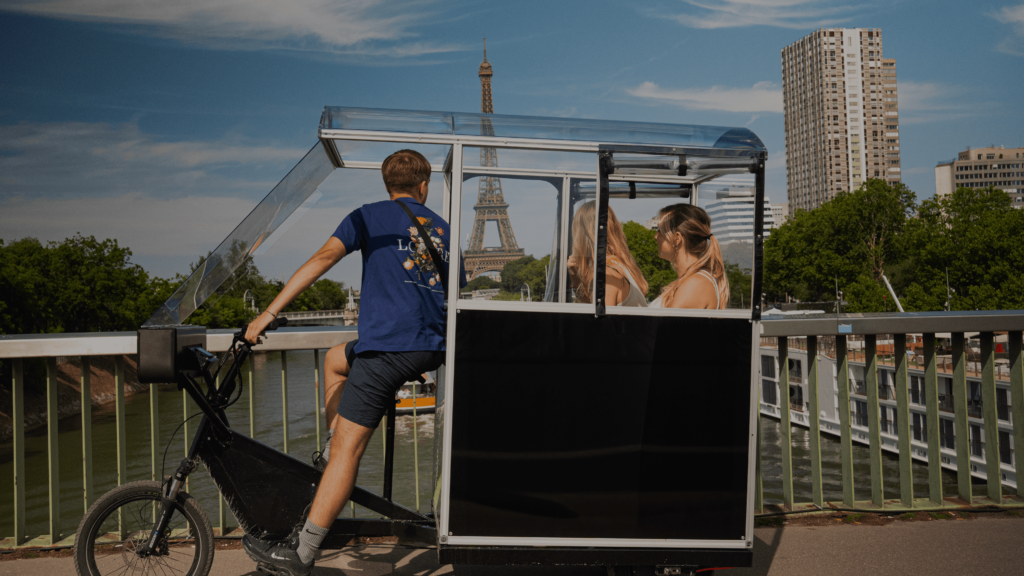 Photo d'un triporteur drop face à la tour eiffel